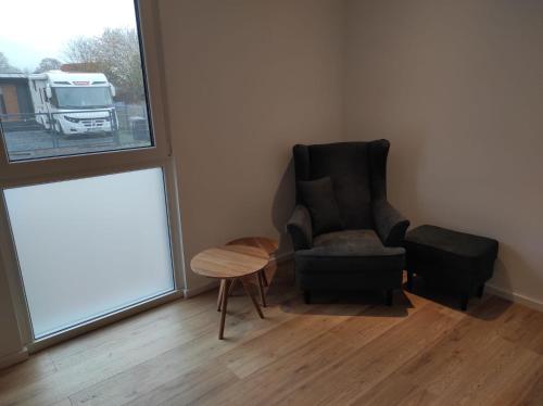 a living room with a chair and a table and a window at Seepark 13a in Goch