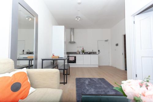a living room and kitchen with a couch and a table at One bedroom serviced apartment Smethwick F312 in Birmingham