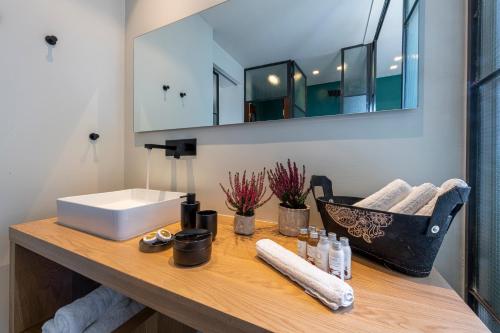 ein Badezimmer mit einer Theke mit einem Waschbecken und einem Spiegel in der Unterkunft Hidesign Athens Acropolis Panorama Suite in Athen