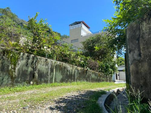 an old concrete wall with a building in the background at Aurelia inn in Kandy