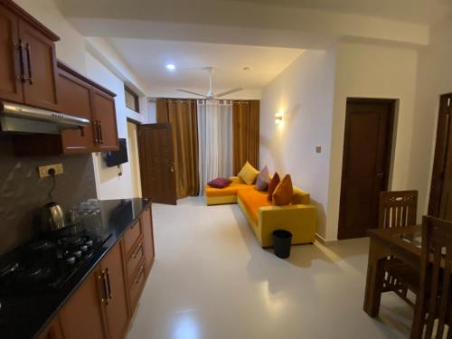 a living room with a yellow couch in a kitchen at Aurelia inn in Kandy