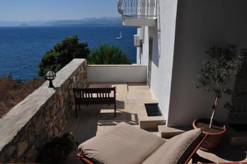a balcony with a bench and a view of the ocean at Ece Hotel Sovalye Island in Fethiye
