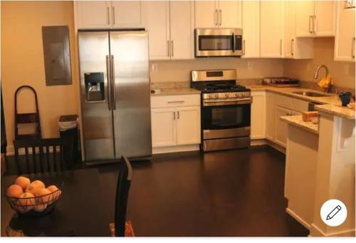 a kitchen with white cabinets and stainless steel appliances at Entire 3 bedroom Private Luxury Condo in Washington, D.C.