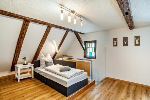 a bedroom with a bed in a room with wooden floors at Schwarzwaldtani - Städtle in Bühl