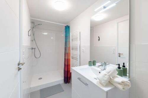 uma casa de banho branca com um lavatório e um chuveiro em Student Factory Lyon Parilly em Vénissieux