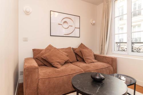 a living room with a couch and a table at Apart hotel Centre de Paris by Studio prestige in Paris