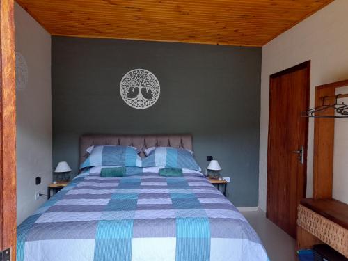 1 dormitorio con 1 cama con edredón azul y blanco en Chalé Brisa do Vale, en Santa Luísa de Baixo
