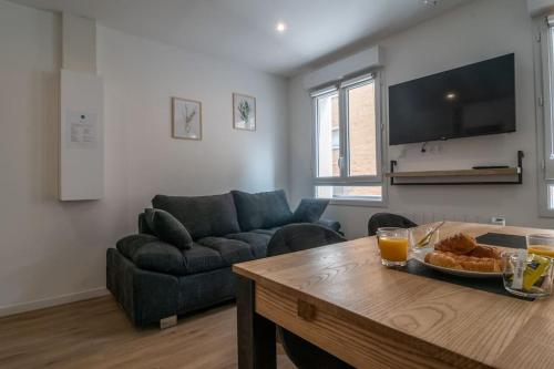 un salon avec une table et un canapé dans l'établissement F2 hypercentre - Proche gare - WIFI gratuite, au Havre