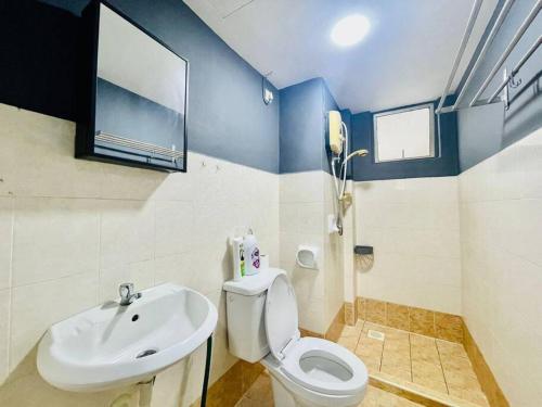 a bathroom with a white toilet and a sink at 8 pax Homestay near Axiata Arena & Pavilion 2 in Kuala Lumpur