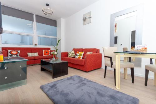 uma sala de estar com um sofá vermelho e uma mesa em One Bedroom apartment Serviced apartment Smethwick flat 315 em Birmingham