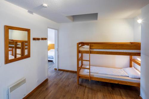 une chambre avec deux lits superposés et un miroir dans l'établissement SUNWEB Chalets de Bois Méan, aux Orres