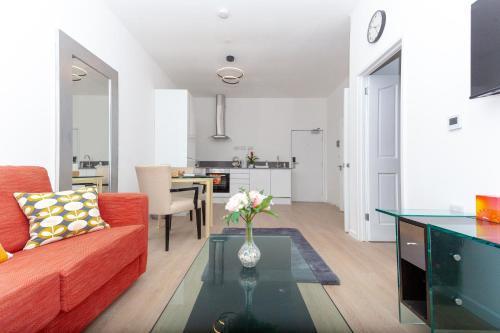 uma sala de estar com um sofá vermelho e uma mesa em One Bedroom apartment Serviced apartment Smethwick flat 315 em Birmingham
