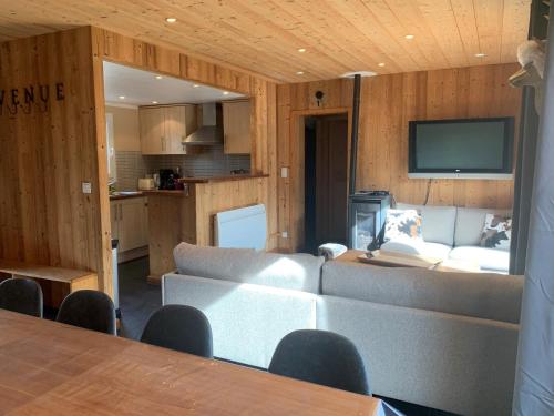 a living room with a couch and a tv at Chalet Barcelonnette in Barcelonnette