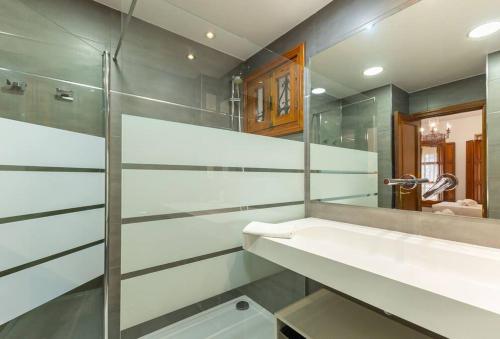 ein Bad mit einem Waschbecken und einem Spiegel in der Unterkunft Santa Cruz Refinadores Suite by Valcambre in Sevilla