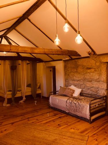 a bedroom with a bed in a stone wall at The Loft With a View in Cabeceiras de Basto