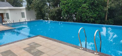 una piscina azul con dos barras de metal. en Winter Note Resorts en Munnar