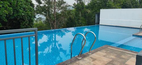 a blue swimming pool with two metal rails next to it at Winter Note Resorts in Munnar