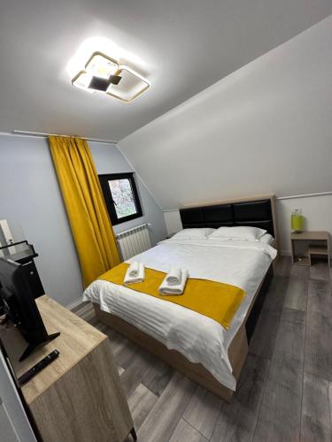 a bedroom with a large bed and a television at Cabana Green Hill in Borşa