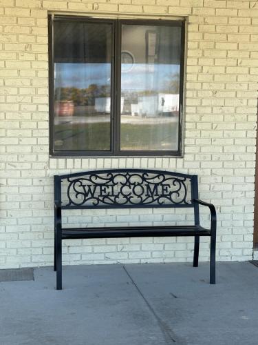 a black bench sitting in front of a window at Paxton Inn Motel in Paxton