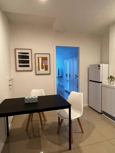 a kitchen with a table and chairs and a refrigerator at CBD Pink!Studio 1 Bedroom FreeParking in Sydney