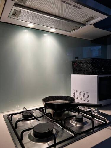 a stove top oven in a kitchen with a microwave at CBD Pink!Studio 1 Bedroom FreeParking in Sydney