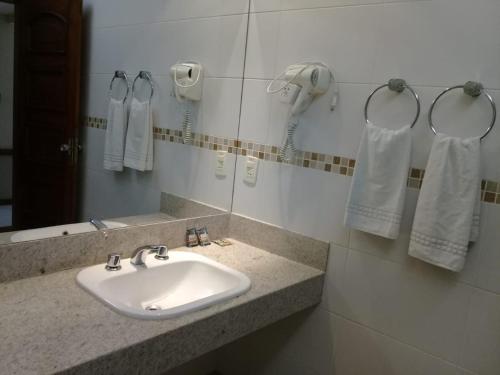 a bathroom with a sink and a phone and towels at Hotel Dominguez Master in Nova Friburgo