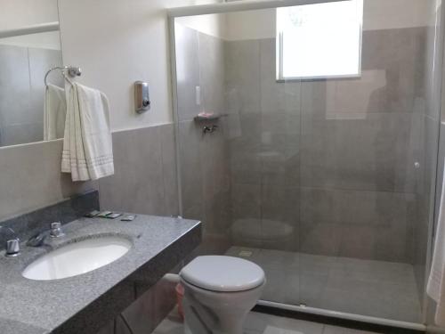 a bathroom with a shower and a toilet and a sink at Hotel Dominguez Master in Nova Friburgo