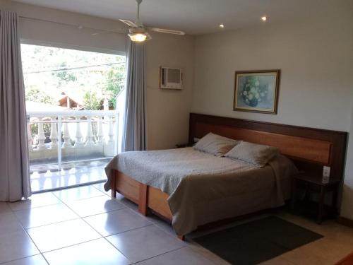 a bedroom with a bed and a large window at Hotel Dominguez Master in Nova Friburgo