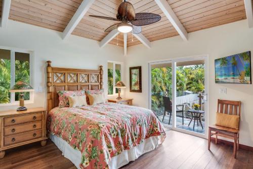 1 dormitorio con 1 cama y ventilador de techo en Kona Beach Bungalows, en Kailua-Kona