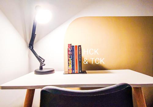 a desk with a lamp and books on it at Next2Mall at Sunway Velocity Two by HCK in Kuala Lumpur