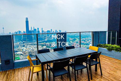 a table and chairs on a balcony with a view of a city at Next2Mall at Sunway Velocity Two by HCK in Kuala Lumpur