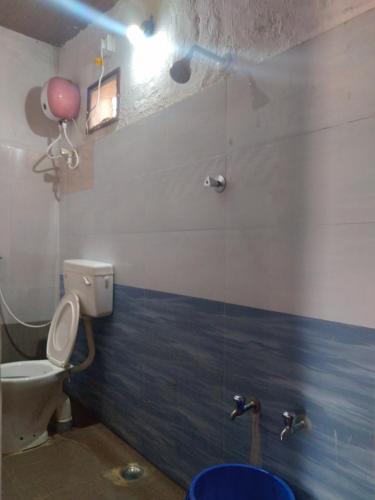 a bathroom with a toilet and a pink balloon on the wall at John home stay in Yelagiri