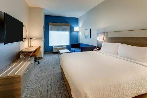 Habitación de hotel con cama grande y escritorio. en Holiday Inn Express Leland - Wilmington Area, an IHG Hotel, en Leland