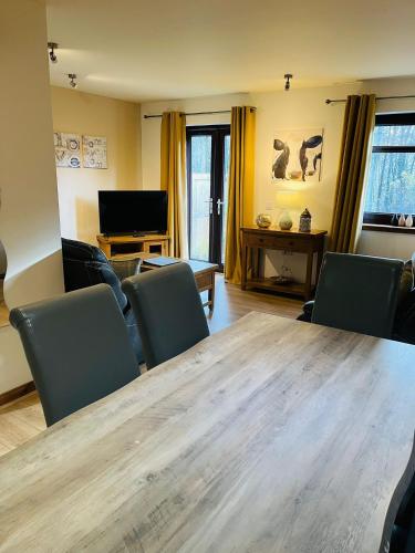 a living room with a large wooden table and chairs at The Galleries No 3 in Spean Bridge