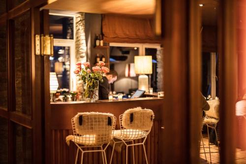 a room with a bar with two chairs and a person in the mirror at Design Hotel Miramonte in Bad Gastein