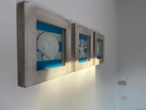 a row of framed pictures on a wall at Apartamento Binibeca Nou Cami de Cavalls in Binibeca