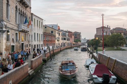a boat traveling down a canal in a city at Hotel Nani Mocenigo Palace in Venice