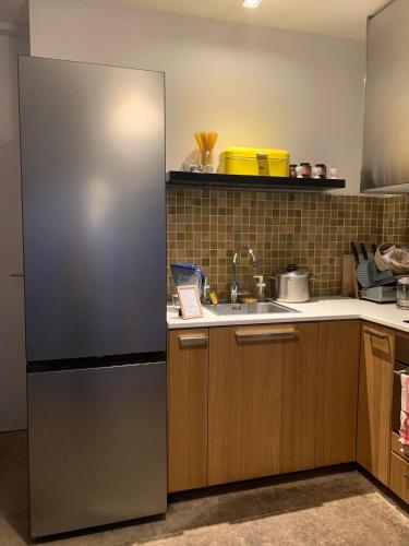 a kitchen with a stainless steel refrigerator and a sink at B&B DRUUM in Brussels
