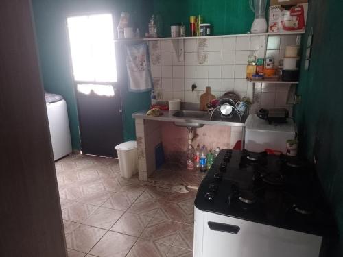 eine kleine Küche mit Herd und Spüle in der Unterkunft Casa Mobiliada in Manaus