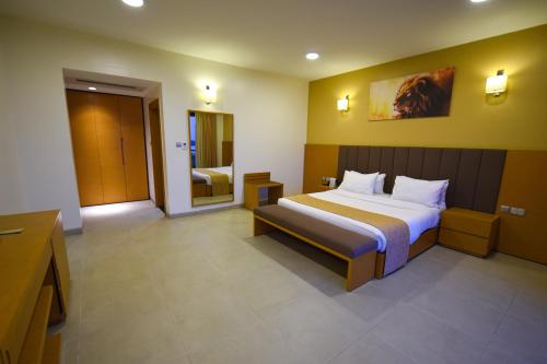 a hotel room with a bed and a bathroom at K Hotels Entebbe in Entebbe