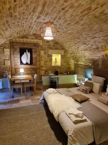 a bedroom with a large bed and a table at Le Clos de la Tour in Sainte-Nathalène