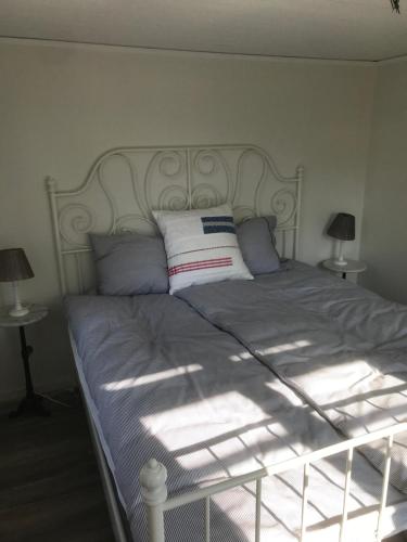a bed with a white headboard and pillows on it at Ankiborg Bed and Breakfast in Färjestaden