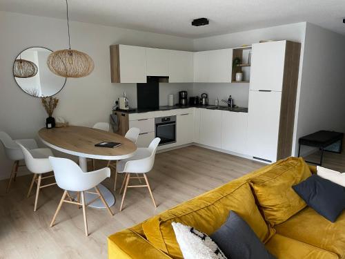 a living room with a couch and a table and a kitchen at Holland 7 im Torrentblick brandnew family appartment in Leukerbad