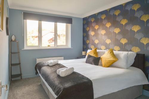 Bamber BridgeにあるHuntsfield House- Stunning Modern 4 Bedroom House Suitable for Work and Leisure Staysのベッドルーム1室(大型ベッド1台、黄色い枕付)
