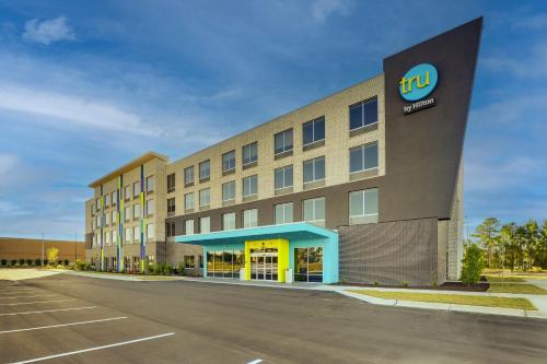 an office building with a sign on the side of it at Tru By Hilton Leland Wilmington in Leland