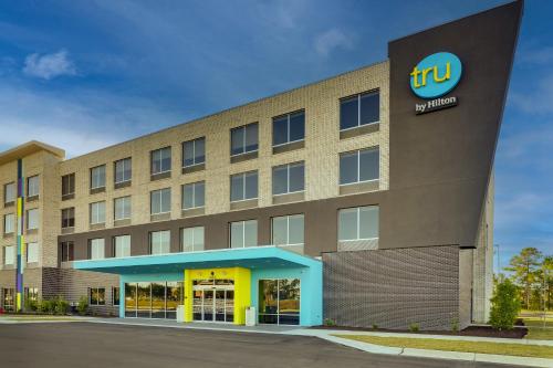 an office building with a hotel sign on the side at Tru By Hilton Leland Wilmington in Leland
