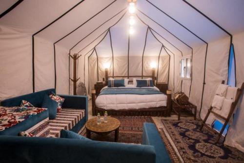um quarto com uma cama numa tenda em sunset luxury camp em Merzouga