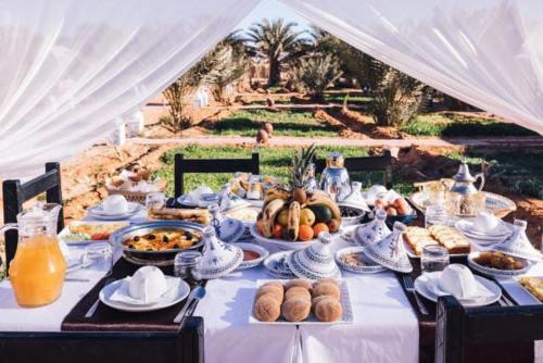 uma mesa longa com comida em cima em sunset luxury camp em Merzouga