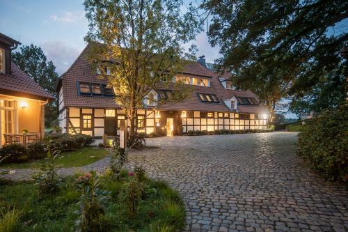 a large house with a cobblestone driveway at SCHLOSSRESIDENZ - Boutique Apartments & Hotel Suiten in Schloß Ricklingen