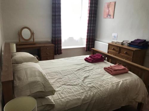 a bedroom with a bed with two red pillows on it at Cherry Tree Cottage, Aysgarth in Leyburn